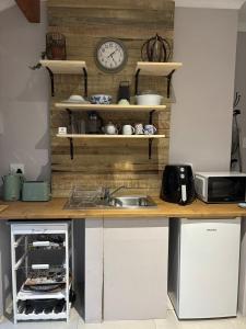 a kitchen with a sink and a clock on a wall at Dune Ridge Cottage in Port Alfred