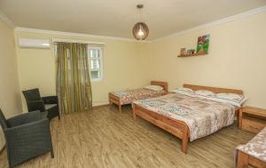 a hotel room with two beds and a chair at Qiwi House in Ureki