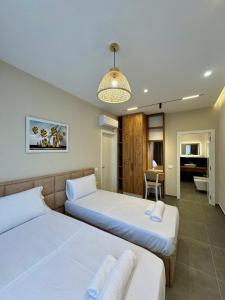 a bedroom with two beds and a dining room at Apartamente Antoni Shengjin in Shëngjin