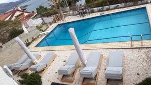 a swimming pool with chaise lounge chairs next to it at ART BLUE Residence - Pool Access Apartment in Aghia Marina