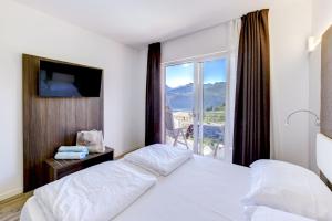 a hotel room with two beds and a large window at Park Hotel Val Di Monte ***S in Malcesine +195 photos