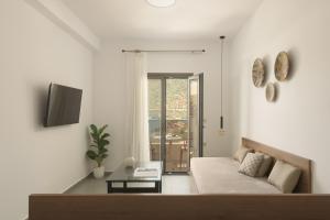 a white living room with a couch and a window at Amalia Apartments-Suites in Bali