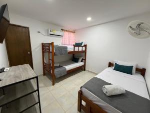 a small room with two beds and a desk at 22 Guest House in Santa Marta