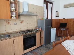 a kitchen with a stove and a refrigerator at Casa della nonna in Donisi
