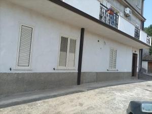 a white building with two windows and a balcony at Casa della nonna in Donisi
