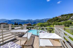 a balcony with white chairs and a swimming pool at Park Hotel Val Di Monte ***S in Malcesine