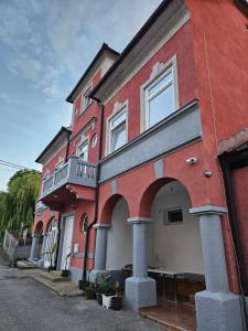a red brick building with a balcony on a street at Apartma 2 in Pekre