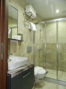 a bathroom with a toilet and a sink and a shower at Roza Taksim in Istanbul +8 photos