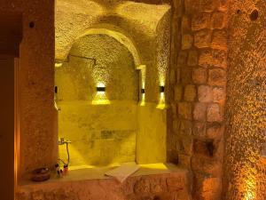 a bathroom with a shower in a stone wall at Masal Cave Suites - Where Story Begins in Ürgüp +65 photos
