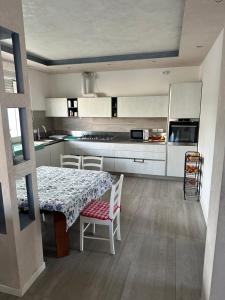 a kitchen with a table and chairs and a kitchen with white cabinets at jesolo wellness house in Lido di Jesolo +9 photos