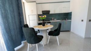 a kitchen with a table with chairs and a vase of flowers at A-frame-WHITE HOUSE-I in Qusar