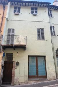 ein weißes Gebäude mit Fenstern und einem Balkon in der Unterkunft Mameli 27 in Spoleto