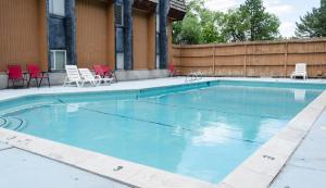 a large swimming pool with chairs and aermottermott at Updated condo in Logan in Logan