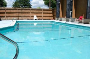 a large blue pool with two chairs in it at Updated condo in Logan in Logan +6 photos