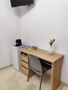 a wooden desk with a vase of flowers on it at Casa vacanze Poma in Custonaci