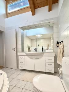 a bathroom with a sink and a toilet and a mirror at Victoria's Home - luxurious penthouse in Saas-Fee +74 photos