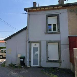 a white building with two windows and a door at Charmante petite maison - 2 chambres in Homécourt