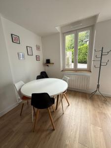 a dining room with a white table and chairs at Charmante petite maison - 2 chambres in Homécourt