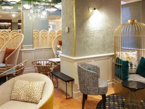 a room with chairs and a birdcage in a store at Mercure Paris Notre Dame Saint Germain des Prés in Paris