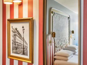 a room with striped walls and a picture and towels at Mercure Paris Notre Dame Saint Germain des Prés in Paris +122 photos