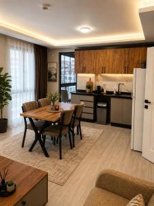 a kitchen and living room with a table and a refrigerator at Airport Deluxe Suites Otel in Trabzon