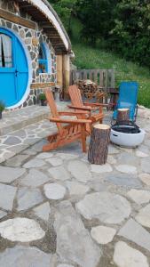 a patio with two wooden benches and two chairs at Nook Hill in Comarnic
