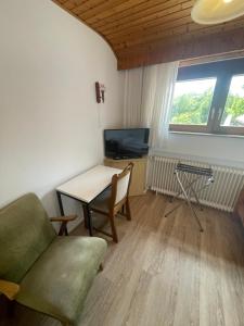 ein Wohnzimmer mit Sofa, Tisch und Fernseher in der Unterkunft Mariennest in Jever