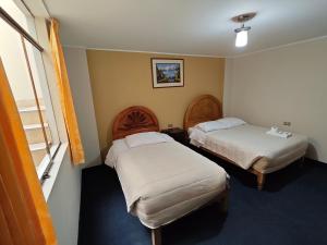 a hotel room with two beds and a window at Hostal Amazonas in Chivay +14 photos