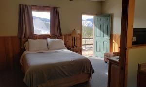 a bedroom with a bed and a large window at Sundance Lodge in Nederland