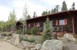 a log cabin with rocks in front of it at Sundance Lodge in Nederland