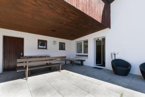 a patio with a bench and a wooden ceiling at 21 Pure relaxation Apartment in Memmingerberg