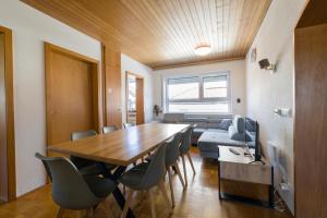 a dining room with a table and chairs and a couch at 21 Pure relaxation Apartment in Memmingerberg +27 photos