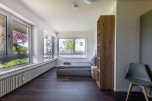 a bedroom with a bed and two windows at 21 Pure relaxation Apartment in Memmingerberg