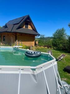 a pool in front of a log house at Wypas Hills - domek na wyłączność in Białka Tatrzańska