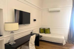 a room with a bed and a television on a wall at Borgo Marsala in Trani