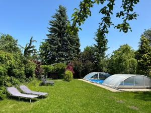 a garden with two domes and two chairs in the grass at Above Apartments in Liptovský Mikuláš