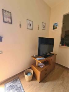 a living room with a flat screen tv on a wooden stand at Casa Antonella in Sìnnai