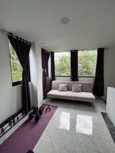 a living room with a bed and two windows at Villa Droom Nest Manado in Manado +90 photos