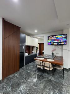 a kitchen with a wooden table and chairs and a television at Villa Droom Nest Manado in Manado