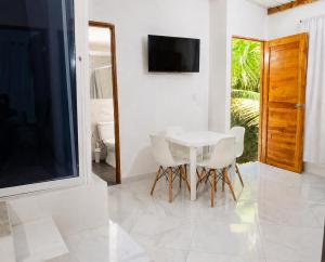 a white dining room with a white table and chairs at Cabaña Los Cristales Coveñas by Amauna in Coveñas