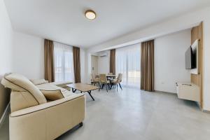 a living room with a couch and a table at Malik Bay RESIDENTS in Bar