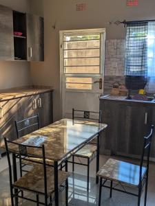 a kitchen with a table and chairs in a kitchen at Maneya Apartments in Kabwe