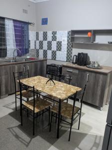 a kitchen with a table and chairs in a room at Maneya Apartments in Kabwe +4 photos