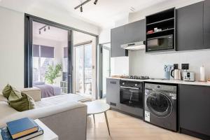 a kitchen with a washing machine and a living room at The Lookout in Cape Town