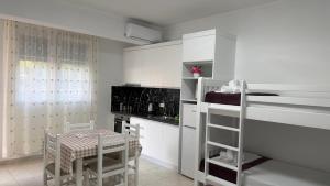 a kitchen with white cabinets and a table and chairs at Amel's Apartments Comfortable Family Stay Near Orikum Beach in Orikum
