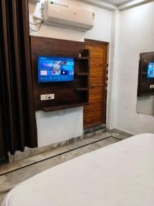 a room with a tv and a bed in a room at Hotel Downtown in Kānpur