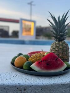 a plate of fruit on a table with a pineapple at CASTLE WHITE by MONARCA in Ríohacha