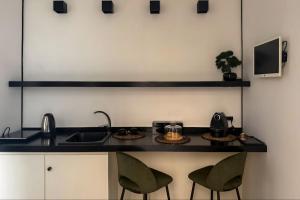 a kitchen with a sink and two green chairs at Borgo Marsala in Trani
