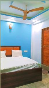 a blue bedroom with a bed with a ceiling fan at Hotel Downtown in Kānpur