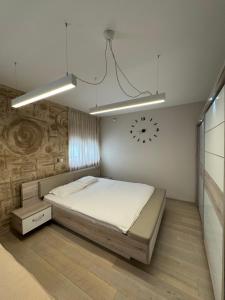 a bedroom with a bed and a clock on the wall at Azure Residence in Pržno